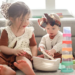 Siblings playing with toys from Lovevery